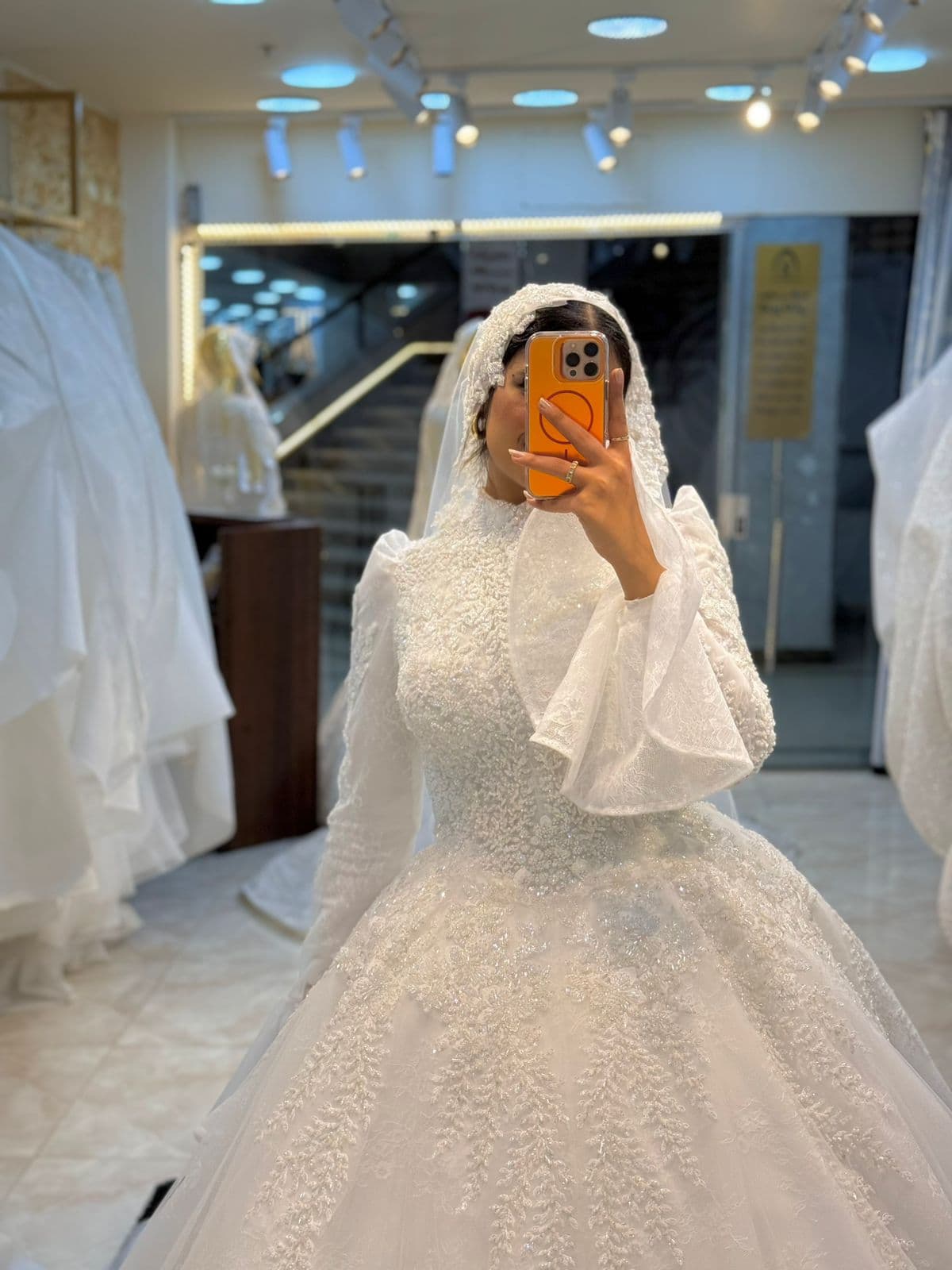 فستان زفاف ملكي بتطريز لؤلؤي وأكمام شفافة فاخرة